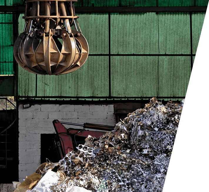 A metallic machine on the top of a hill of waste material